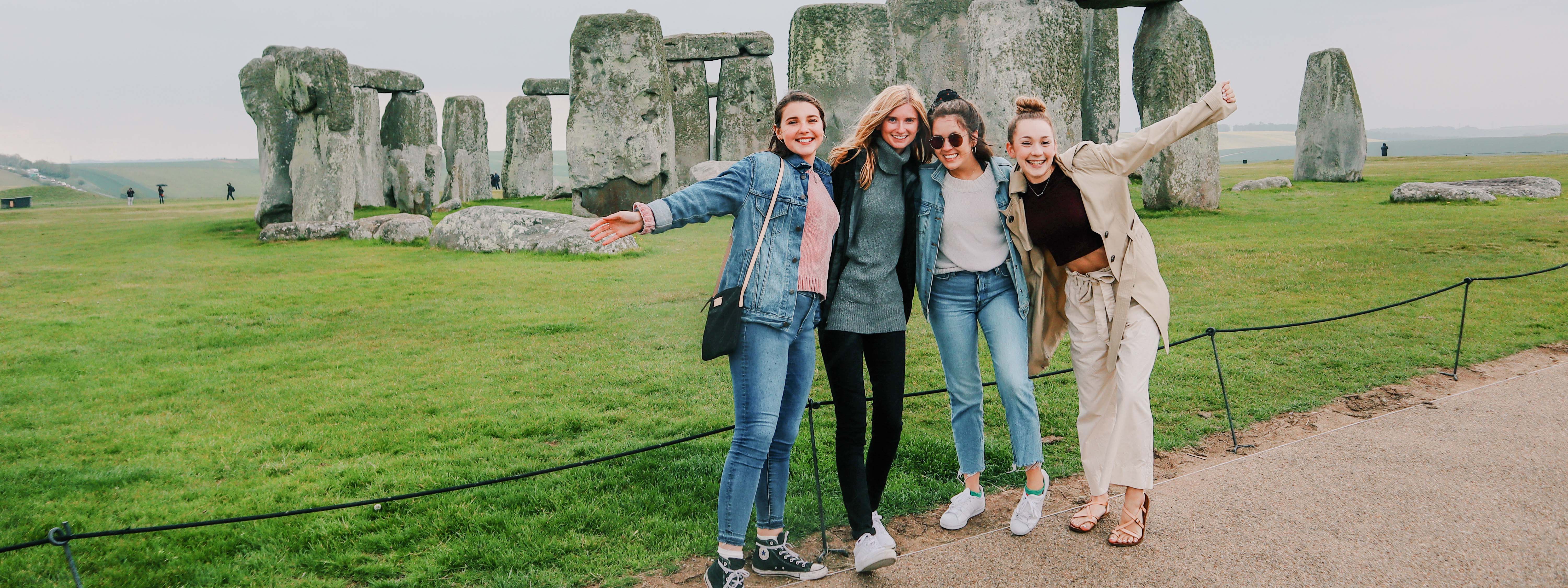 Four FSU students pose in front of Stonehenge in England.